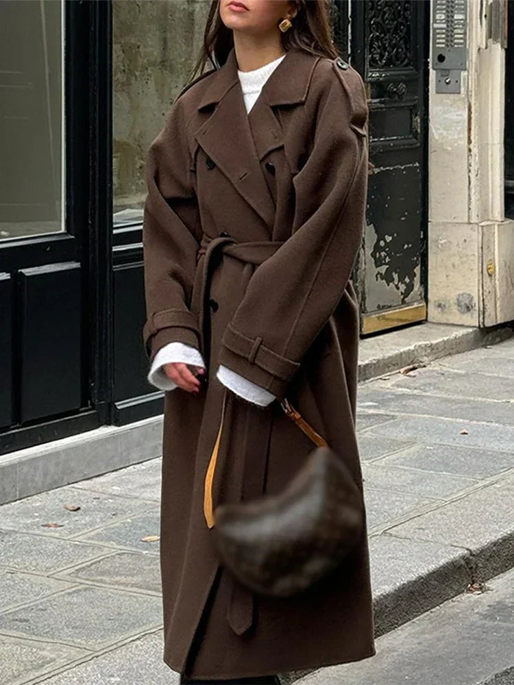 | Elegant maxi coat in a neutral color with double row of buttons and belt