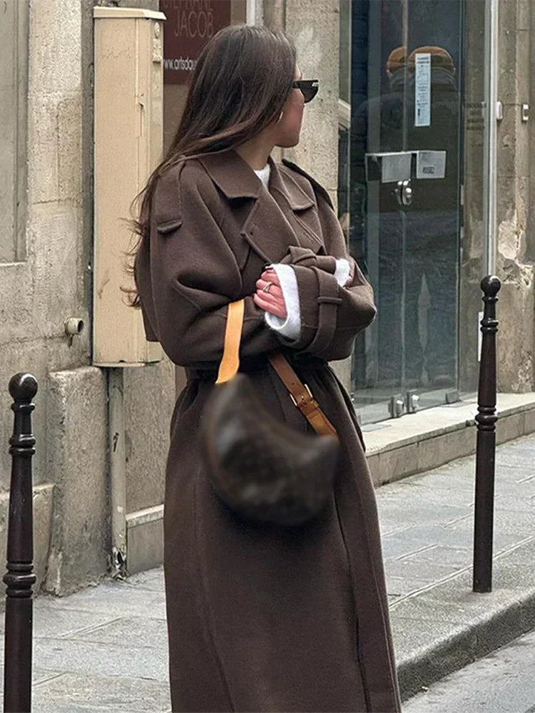 | Elegant maxi coat in a neutral color with double row of buttons and belt